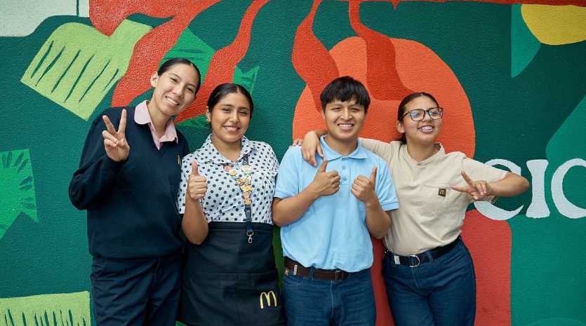 Jóvenes trabajadores de empresas privadas sonriendo, uniforme de tienda